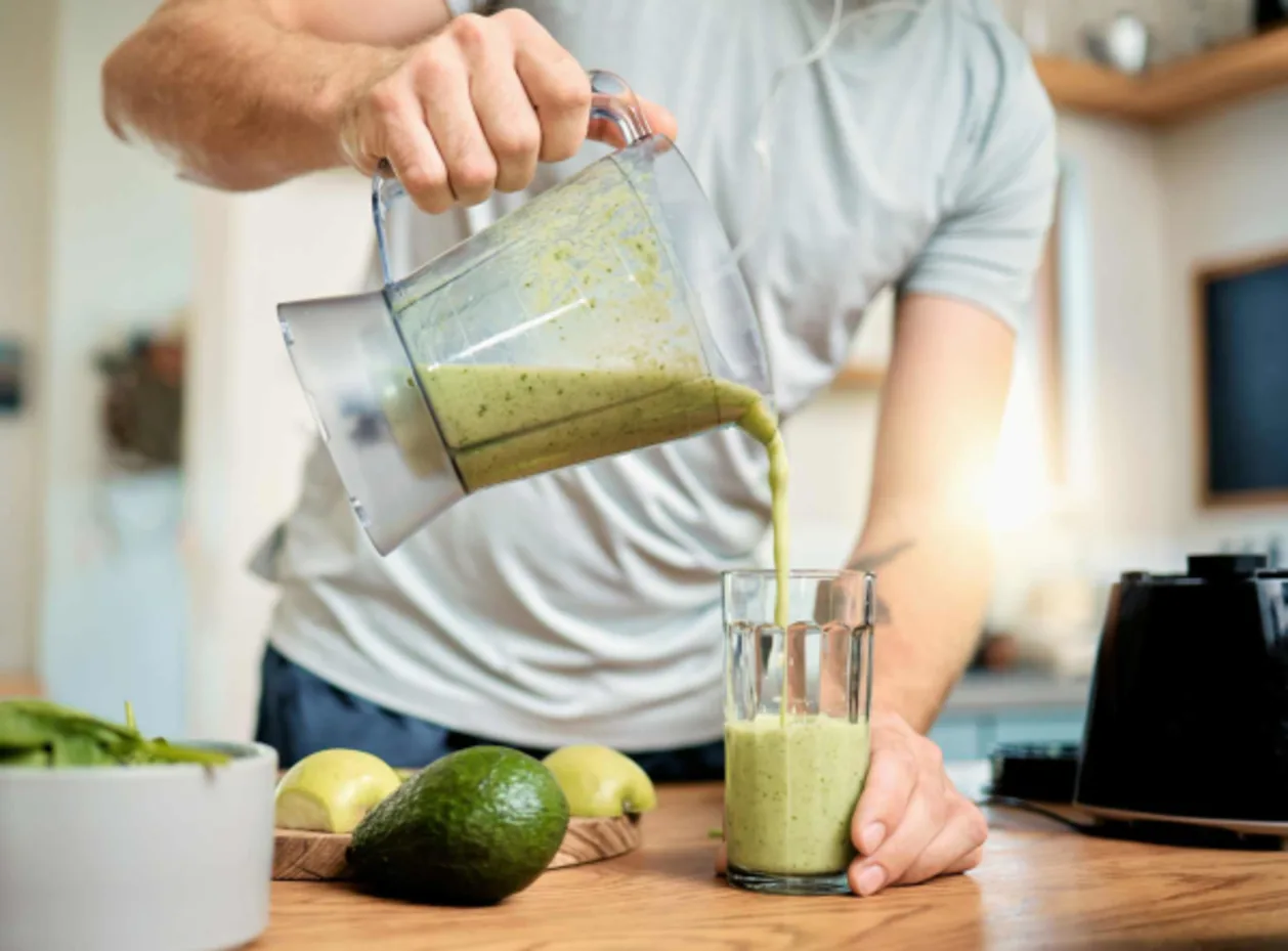 athletic man pouring protein smoothie as part of active nutrition concept